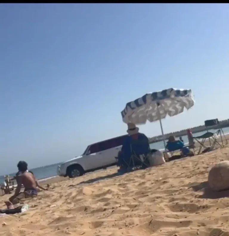 Une voiture à quatre roues motrices agit sur la plage d'Agadir dans l'étonnement des vacanciers